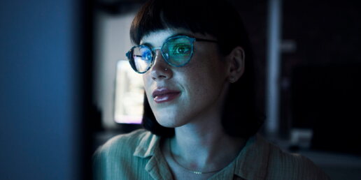 Eine Frau arbeitet am Computer im Dunkeln