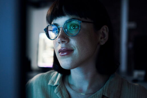 Eine Frau arbeitet am Computer im Dunkeln