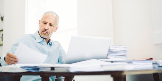 Ein Mann liest Dokumente am Schreibtisch