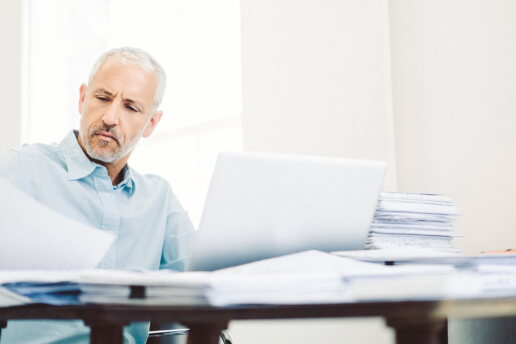 Ein Mann liest Dokumente am Schreibtisch