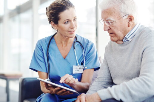 Eine Krankenschwester zeigt dem Patienten etwas auf dem Tablet