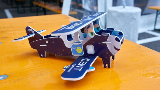 Ein blauer CENT-Papierflugzeug auf dem Tisch.