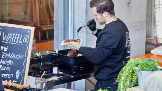 Ein Mitarbeiter bei der Zubereitung einer Waffel.